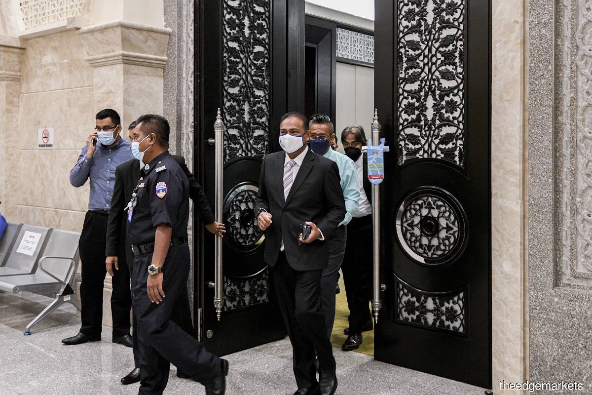 Abdul Azeez (centre) is facing three charges of receiving bribes worth RM5.2 million relating to a road project in Perak and Kedah as well as 10 money laundering charges involving a total of RM13.9 million that he allegedly received from Menuju Asas. (Photo by Mohamad Shahril Basri/The Edge)